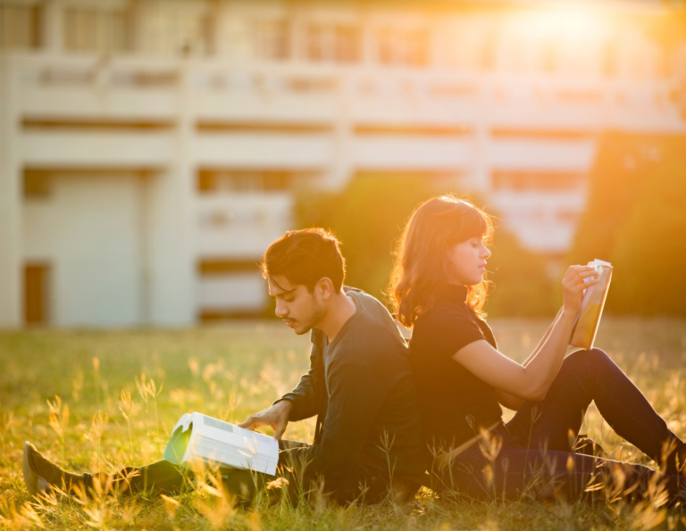 Studenter leser ute på plenen. Foto: Shutterstock skalert