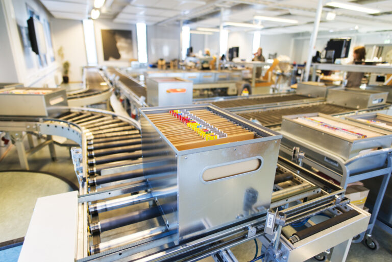 Metallkasser med bøker på et bånd