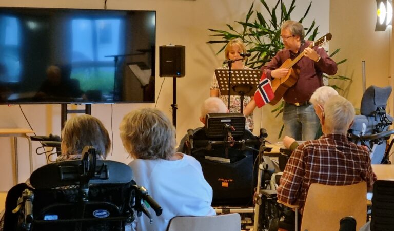Markering av Read Hour fredag 8. september 2023, hvor Anneli Tandy og Tor Holmstad fra Harstad bibliotek besøkte Slottet sykehjem med høytlesing og allsang