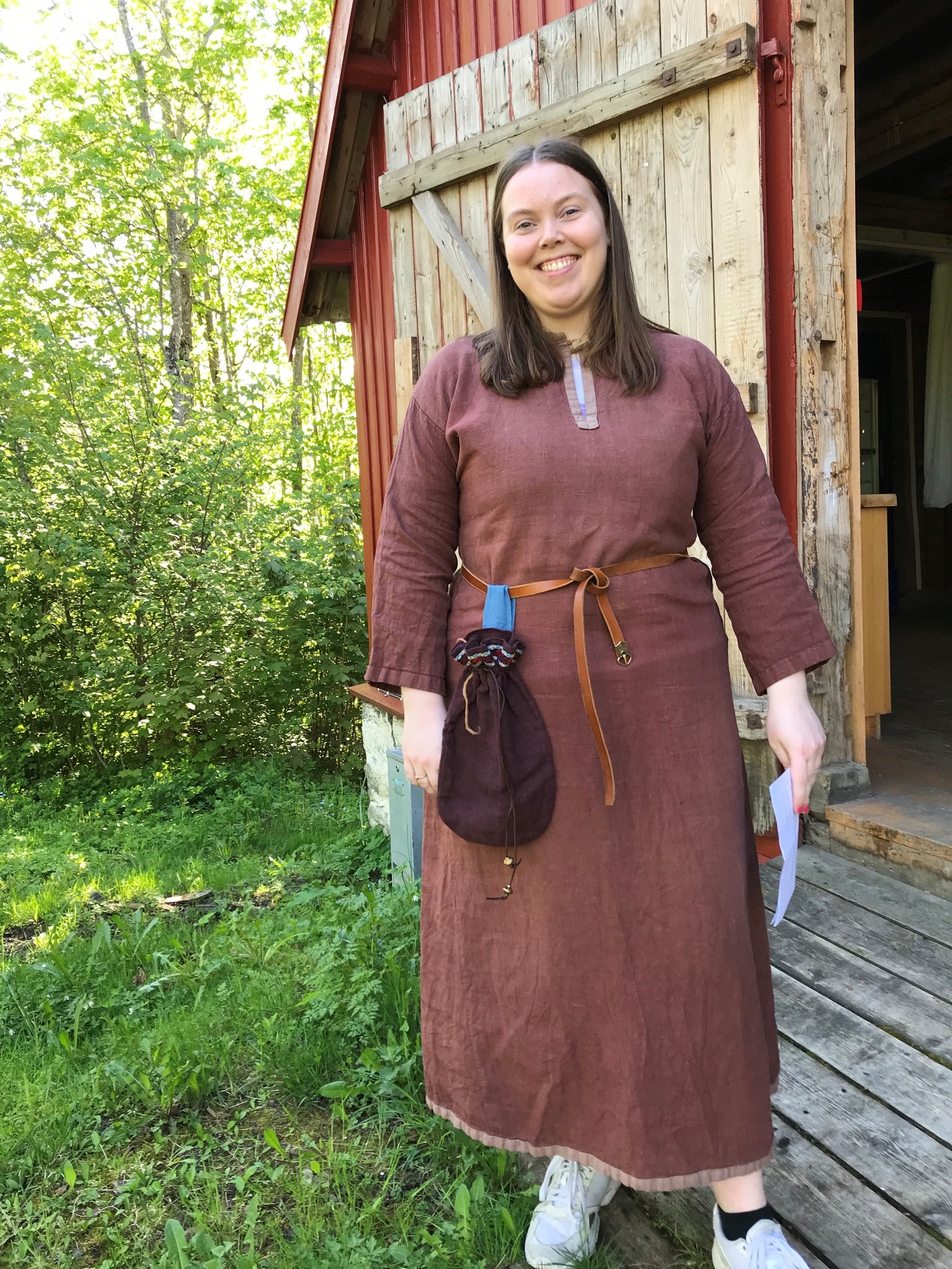 Arrangør i rollen som vikingkvinnen Sigrid fra Egge med vikingklær foran låve.