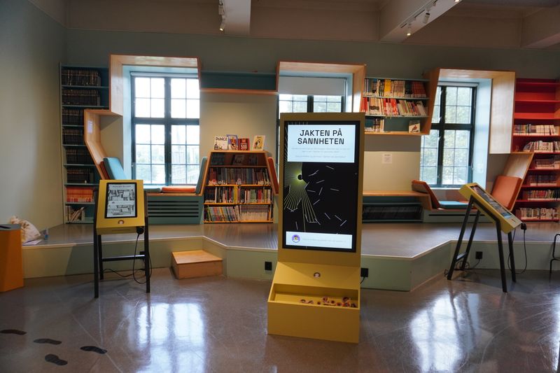 Digitale stasjoner på stativ med interaktiv utstilling i biblioteket. Foto: tenk.faktisk.