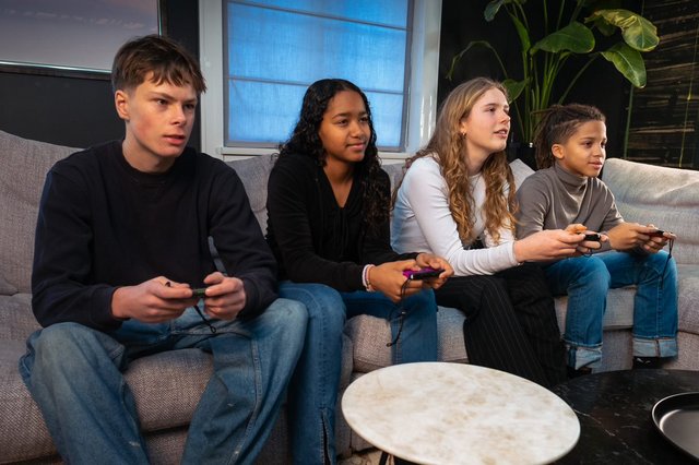 fire ungdommer spiller spill i en sofa