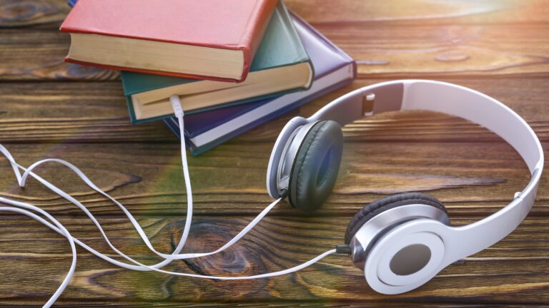 Høretelefon med ledning som ender opp i en bok