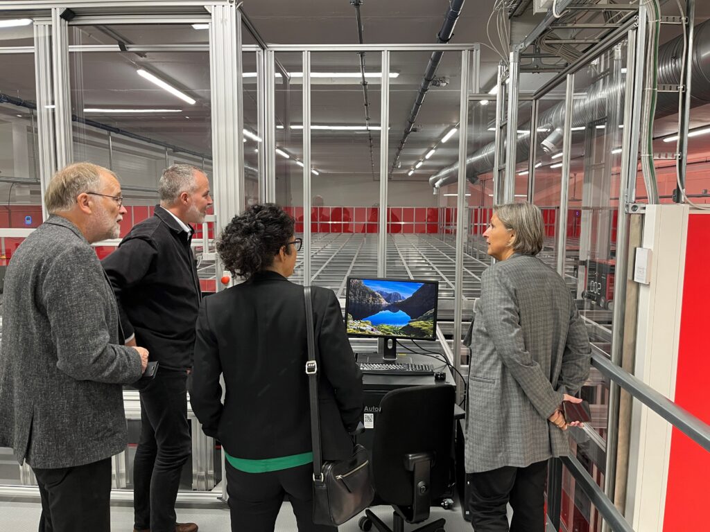 omvisning av besøkende som ser på oversiden av autostore kasselagringssystem