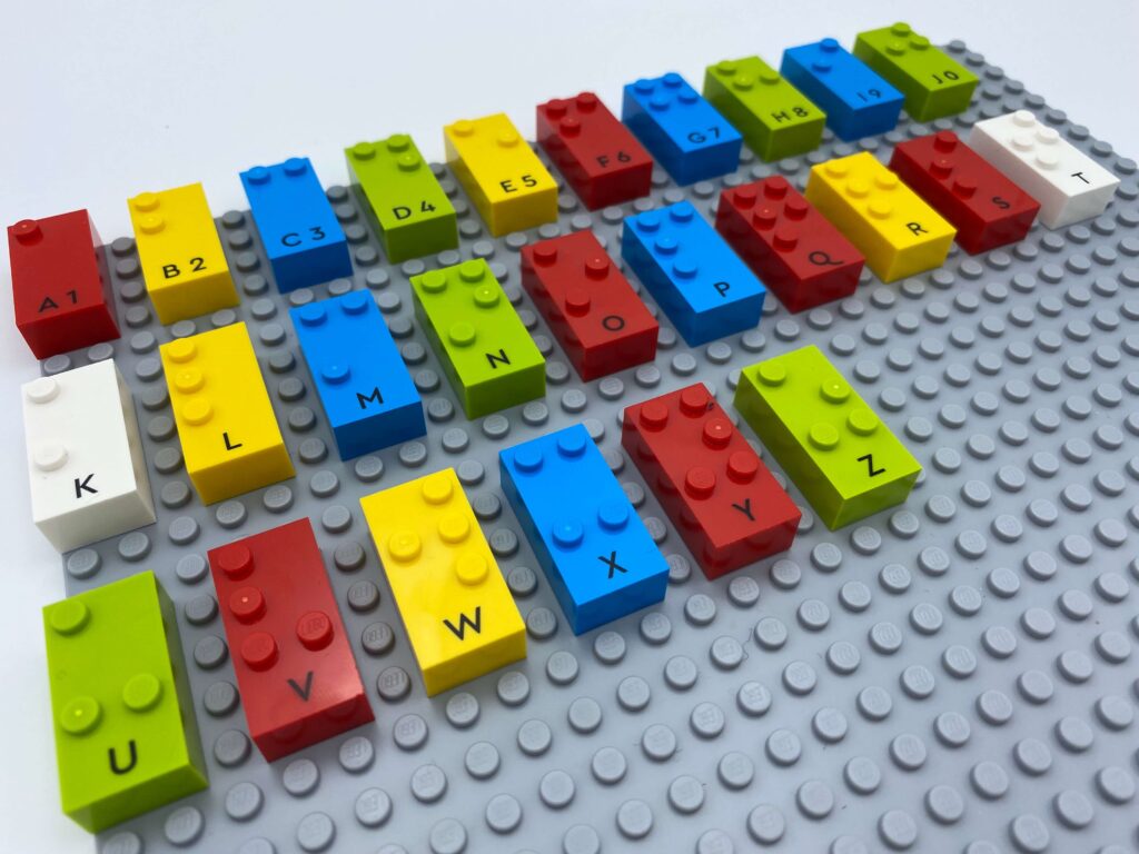 Legoklosser med bokstaver og tall i punktskrift.