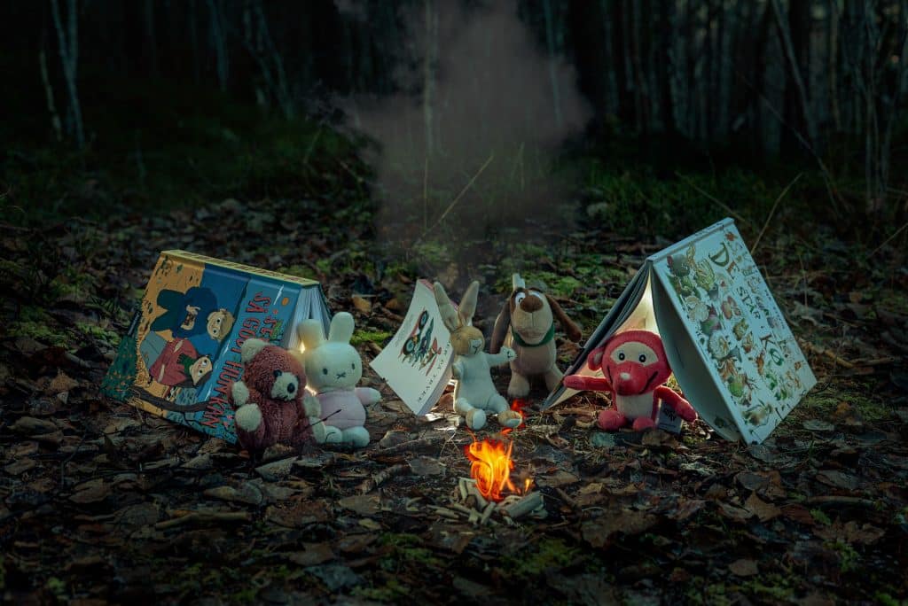 teltleir av bøker med litterære figurer sitter rundt bål